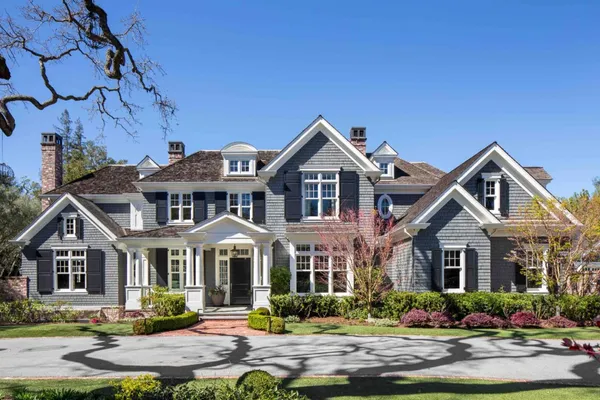 a front view of a house with a yard and potted plants
