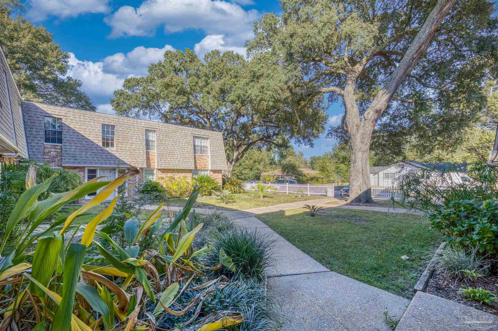 8101 Tippin Avenue, Unit D Pensacola, FL 32514 - Photo 2 of 18 a backyard of a house with a garden and plants