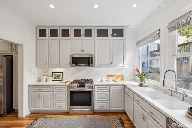 a kitchen with stainless steel appliances a stove microwave and sink