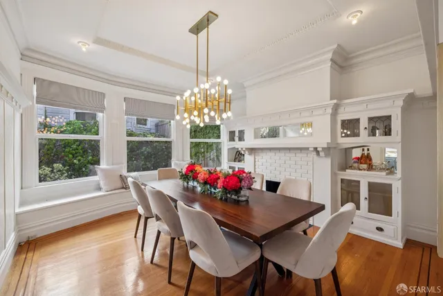 a view of a dining room with furniture a chandelier and wooden floor