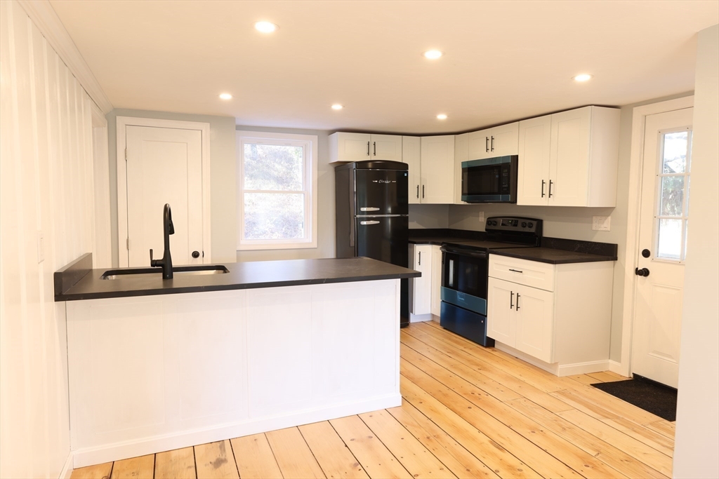 25 Center Hill Road Plymouth, MA 02360 - Photo 6 of 27 a kitchen with stainless steel appliances granite countertop a sink and a stove top oven