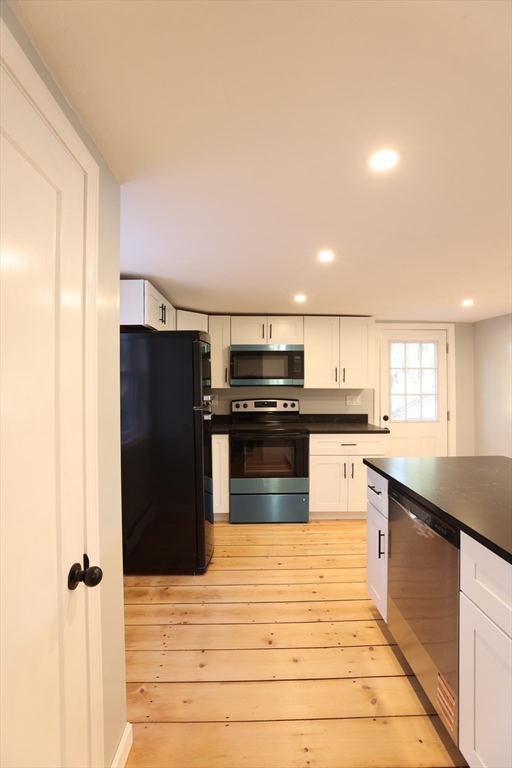 25 Center Hill Road Plymouth, MA 02360 - Photo 8 of 27 a kitchen with stainless steel appliances kitchen island granite countertop a refrigerator and a sink