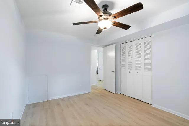 an empty room with a window and a fan