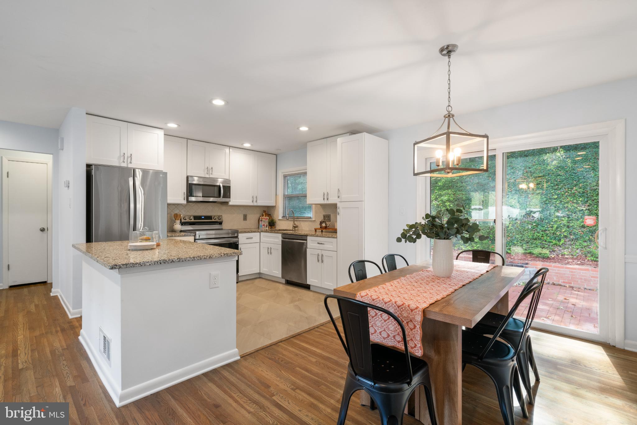 7105 Galgate Drive Springfield, VA 22152 - Photo 22 of 36 a dining room with stainless steel appliances kitchen island granite countertop a dining table chairs and a refrigerator