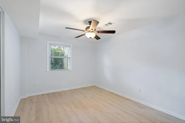 an empty room with a window and a fan