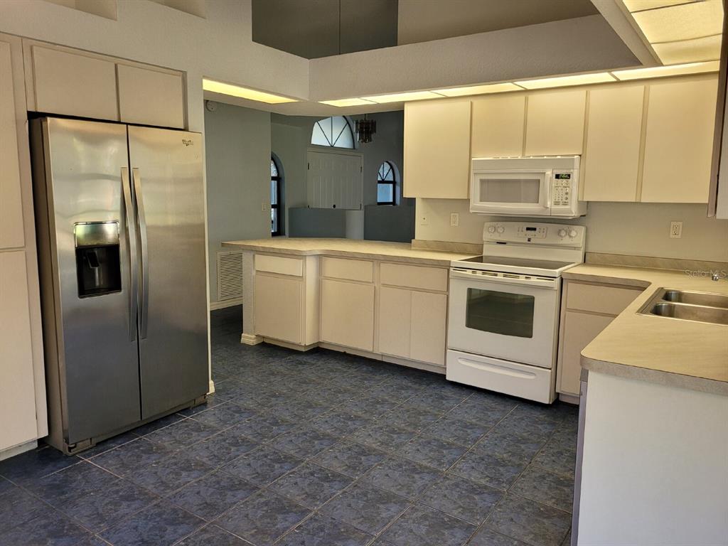 4314 Concert Street Port Charlotte, FL 33948 - Photo 11 of 27 a kitchen with cabinets and stainless steel appliances