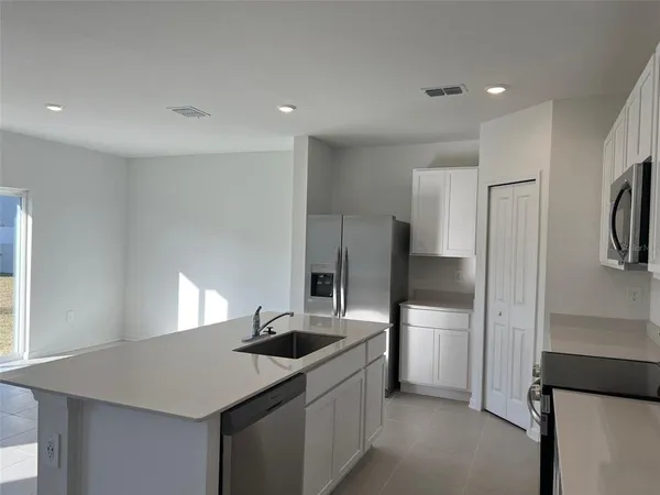 a kitchen with stainless steel appliances granite countertop a refrigerator and a sink