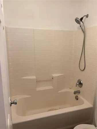 a bathroom with a bath tub with a shower
