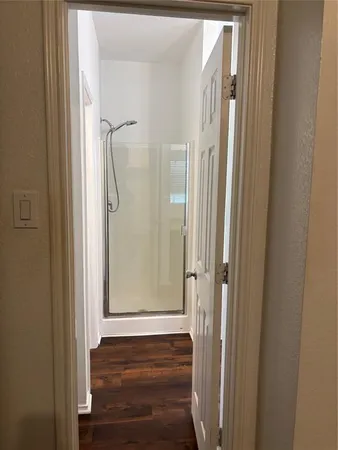 a view of a hallway with wooden floor and entryway