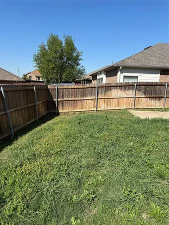 a view of backyard with wooden fence