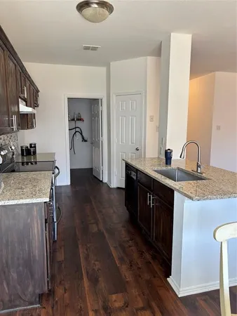 a kitchen with sink cabinets and wooden floor
