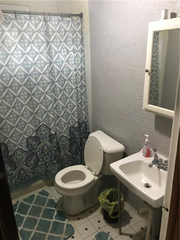 317 Hamilton Street McKees Rocks, PA 15136 - Photo 11 of 38 a bathroom with a toilet a sink and a shower