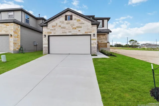 a front view of a house with a yard and ocean view