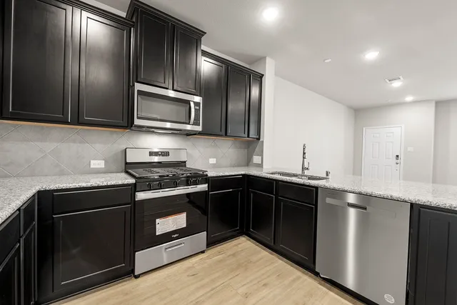 a kitchen with granite countertop stainless steel appliances and wooden cabinets