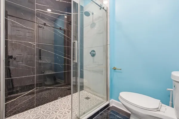a bathroom with a toilet and a shower