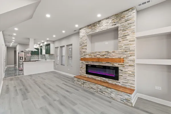 a view of kitchen with stainless steel appliances cabinets and stove top oven