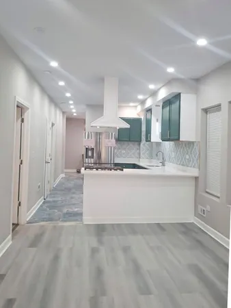 a large kitchen with kitchen island a sink stainless steel appliances and cabinets