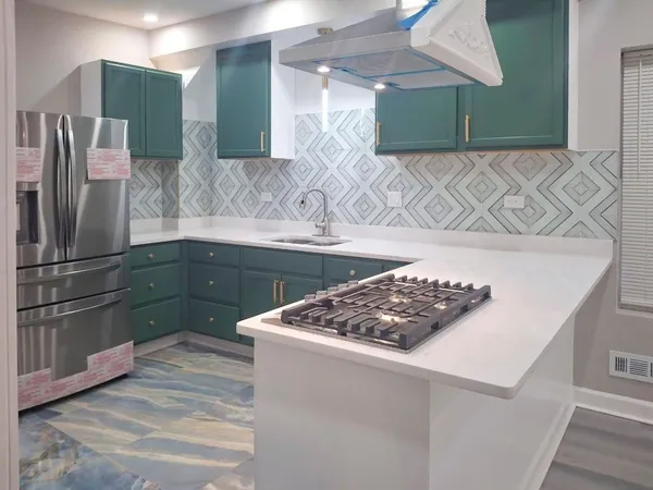 a kitchen with stainless steel appliances granite countertop a sink and a refrigerator