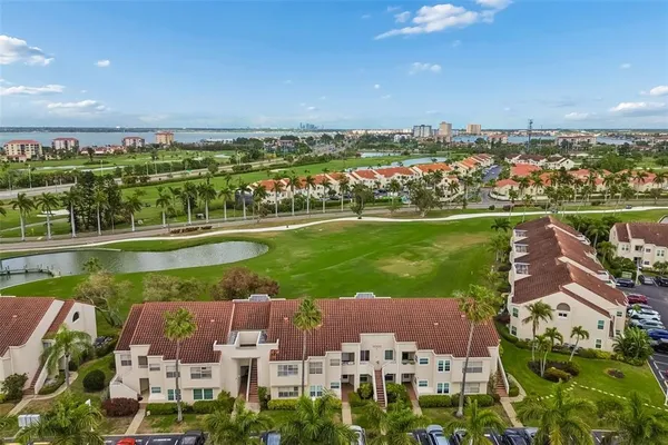 an aerial view of a city with lots of residential buildings ocean and mountain view in back