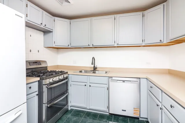 a kitchen with white cabinets and appliances