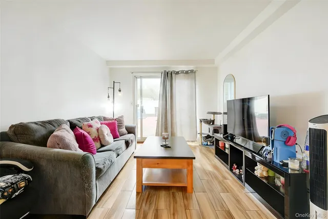 a living room with furniture a wooden floor and next to a window