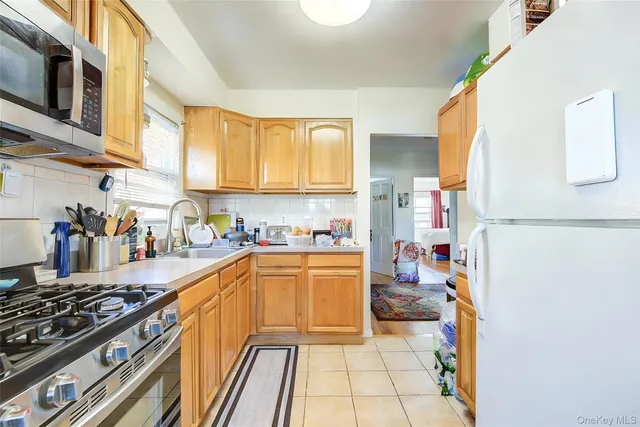 a kitchen with stainless steel appliances granite countertop a stove top oven a sink dishwasher and white cabinets with wooden floor