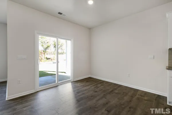 an empty room with wooden floor and fireplace