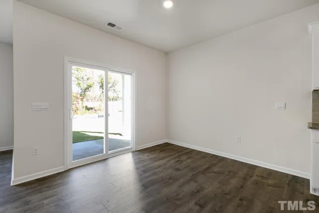 an empty room with wooden floor and fireplace