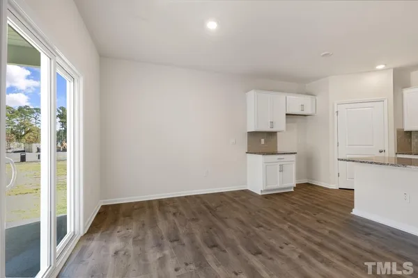 an empty room with wooden floor windows and fireplace