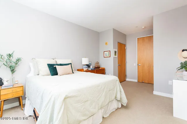 a bedroom with bed and a potted plant