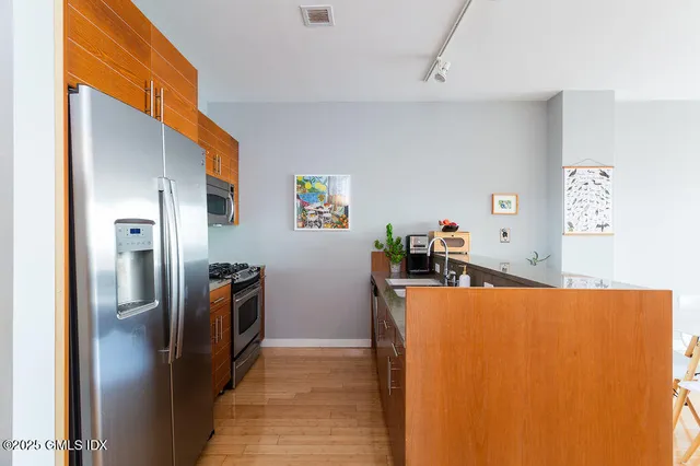 a view of a kitchen with fridge and workspace
