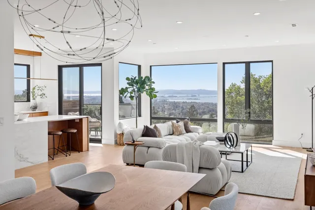 a living room with furniture a large window and a table