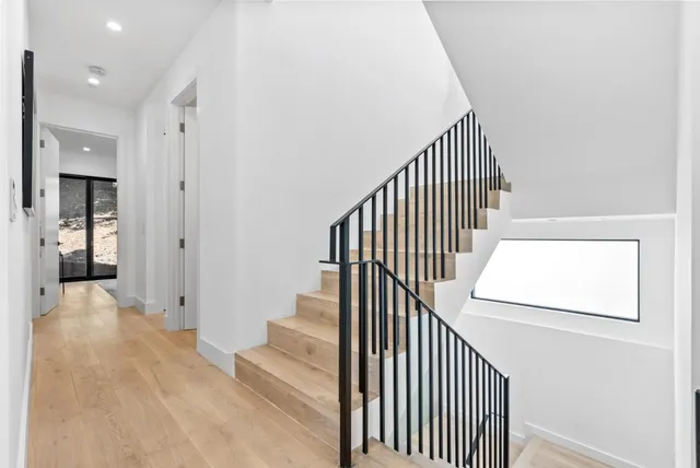a view of a hallway with wooden floor and entryway