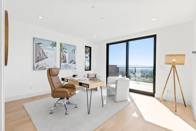a living room with furniture a rug potted plant and a large window