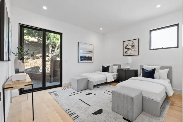 a bedroom with two beds and a large window
