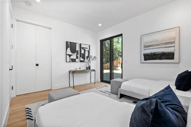 a bedroom with two beds and a painting on the wall