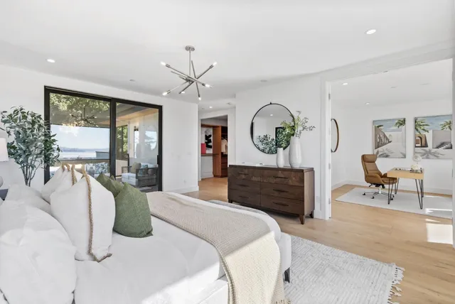 a bed room with a bed mirror furniture and a large window