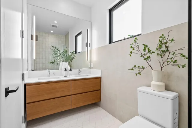 a bathroom with a sink and mirror with toilet