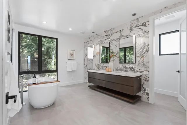 a bathroom with a tub sink and mirror