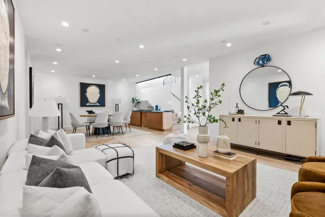a living room with furniture a mirror and a chandelier