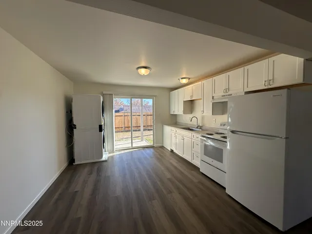 a kitchen with granite countertop white cabinets and white appliances