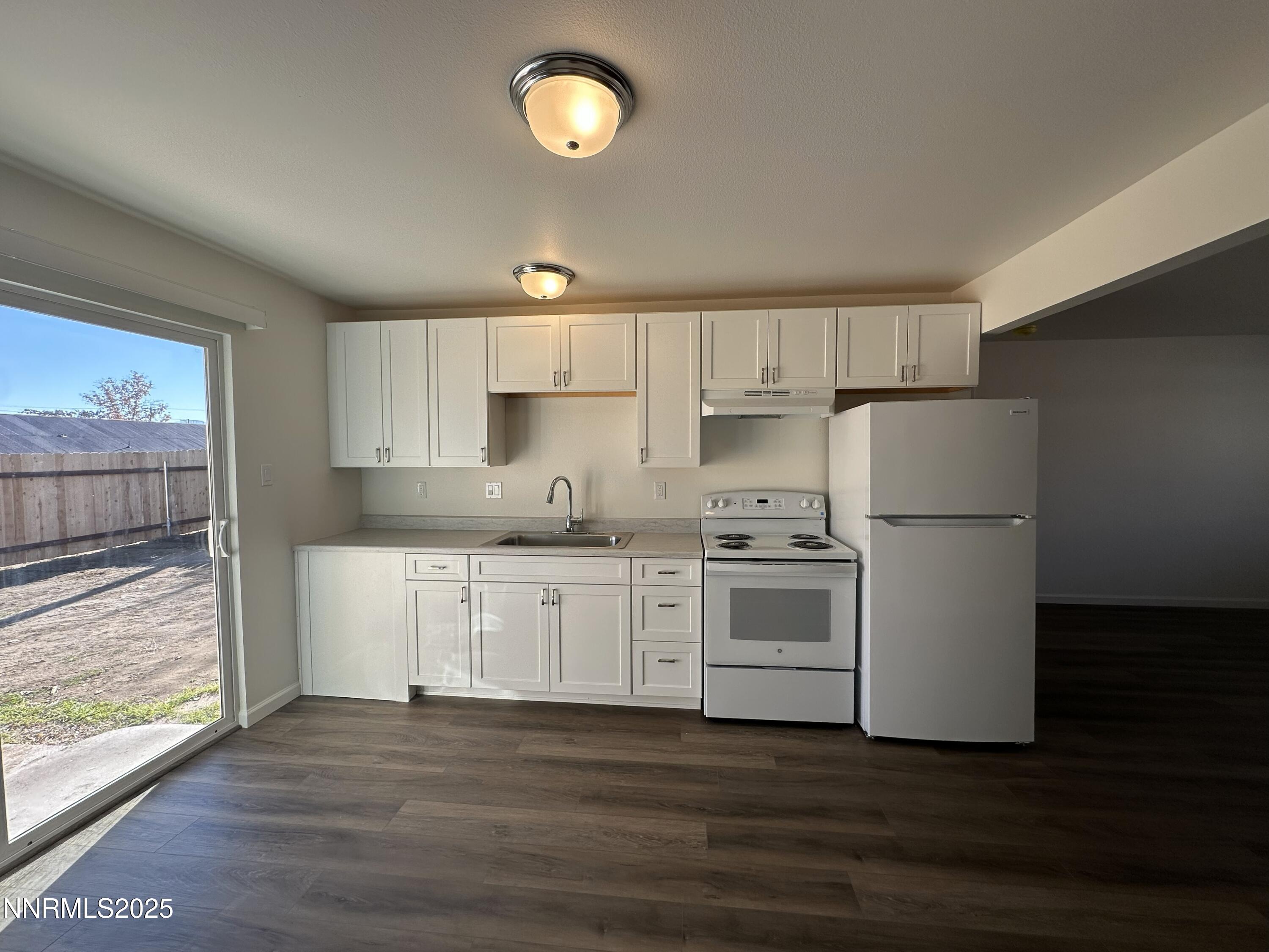 2370 Orange Lane Reno, NV 89502 - Photo 7 of 16 a kitchen with granite countertop white cabinets and white appliances