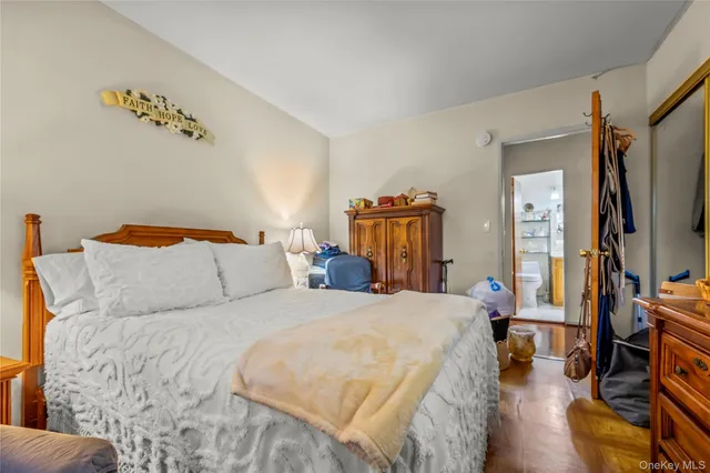 a bedroom with a bed and a flat tv screen on dresser