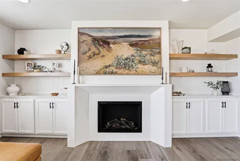 a living room with a fireplace and wooden floor