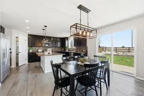 a view of a dining room and livingroom with furniture wooden floor a chandelier