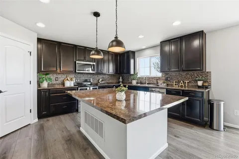 a kitchen with granite countertop stainless steel appliances and wooden cabinets