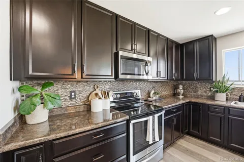 a kitchen with stainless steel appliances granite countertop a sink and cabinets