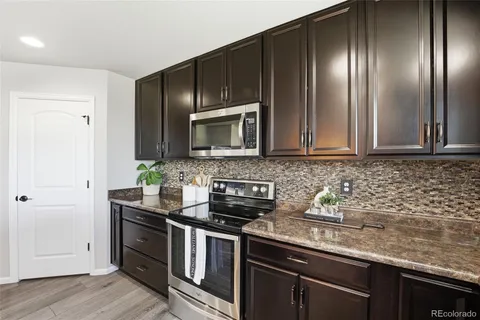 a kitchen with stainless steel appliances granite countertop a stove a sink and a microwave
