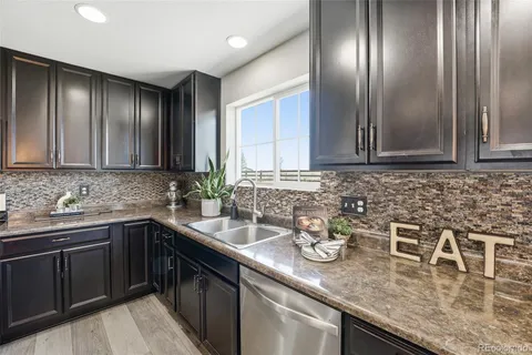 a kitchen with stainless steel appliances granite countertop a sink a stove and cabinets