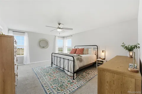 a spacious bedroom that has a bed and a chandelier
